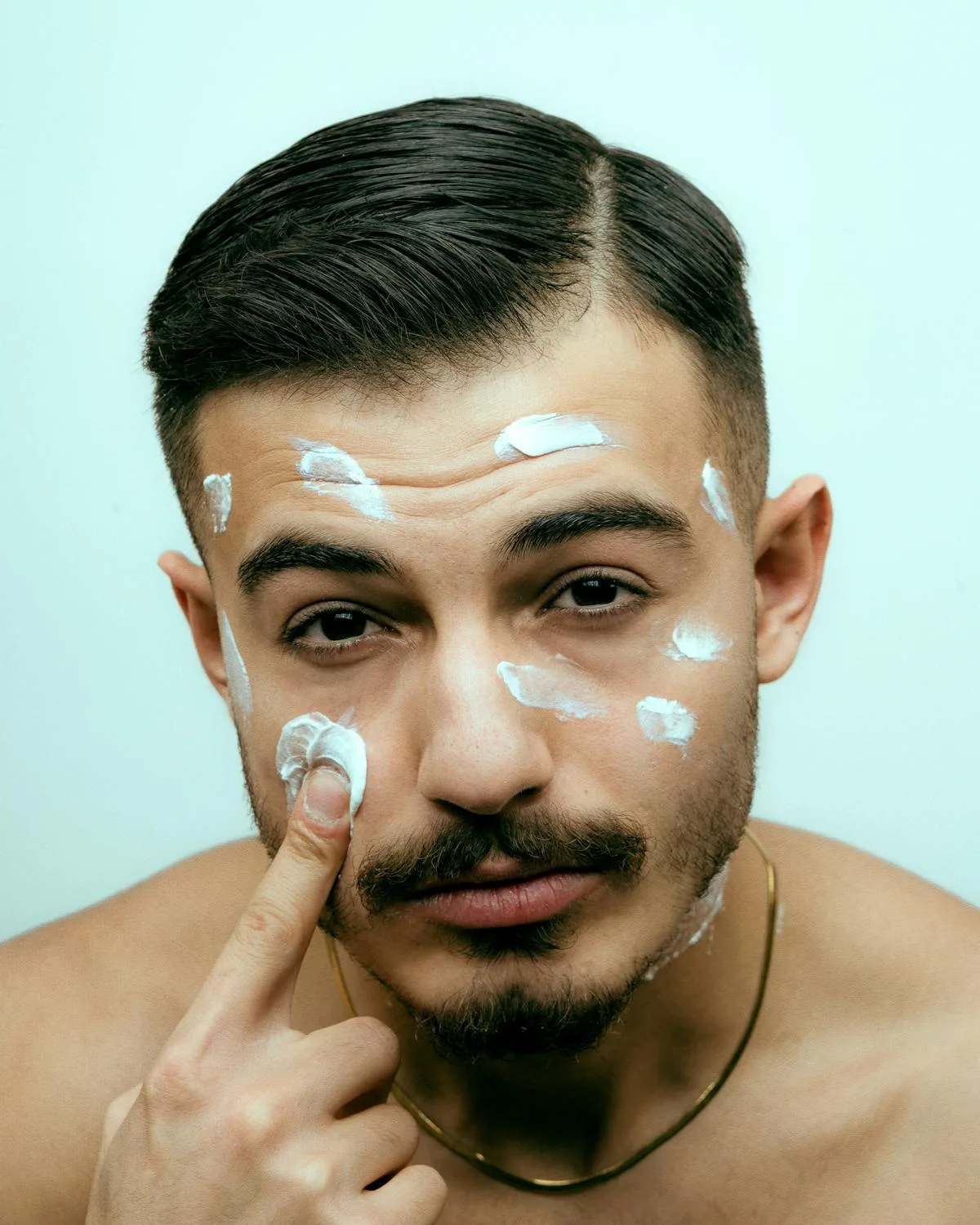 Homme appliquant une crème visage enrichie à l'acide hyaluronique